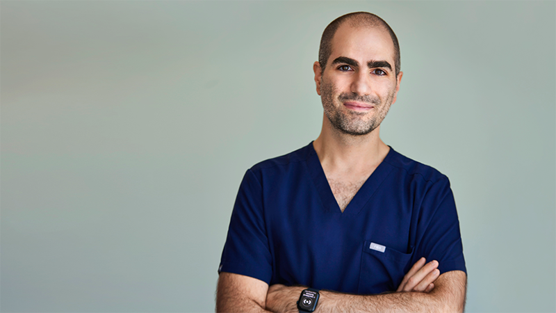 Wissam Rhayem, MD, smiles at camera with crossed arms