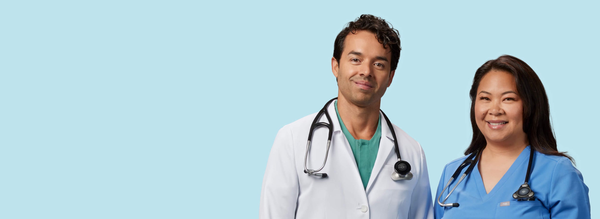 Two smiling clinicians wearing Eko CORE 500™ around their necks vertical format